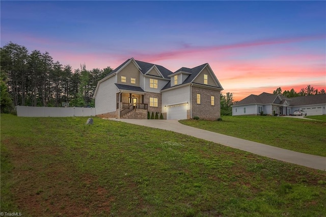 traditional-style house with fence, concrete driveway, a lawn, brick siding, and a garage