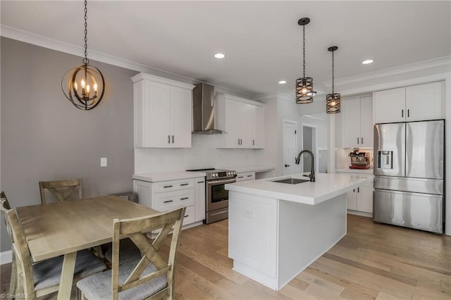 kitchen featuring appliances with stainless steel finishes, light countertops, wall chimney range hood, ornamental molding, and a sink