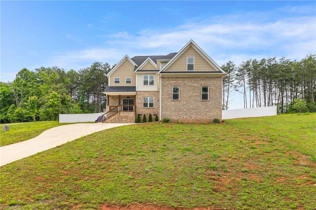 view of front of house with driveway, fence, covered porch, and a front lawn