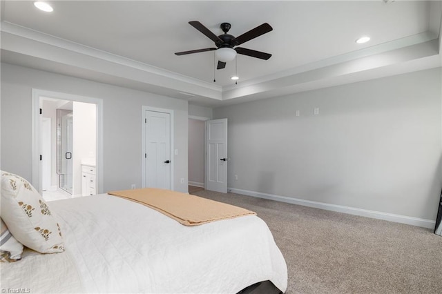 bedroom featuring carpet floors, a raised ceiling, crown molding, ceiling fan, and ensuite bathroom