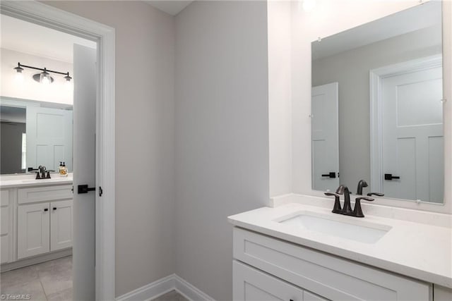 bathroom with tile patterned flooring, two vanities, and a sink