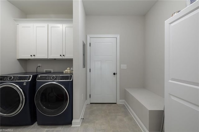 washroom with washing machine and clothes dryer and cabinets