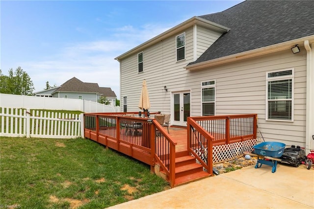 rear view of property with a deck, a yard, fence, roof with shingles, and french doors