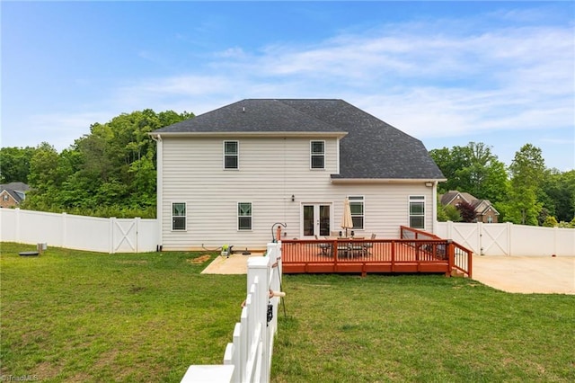 rear view of house with a wooden deck, a patio, and a yard