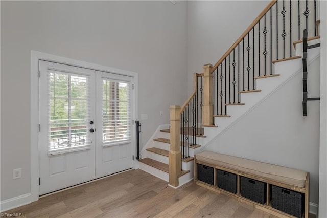 entryway with baseboards, stairway, wood finished floors, and french doors