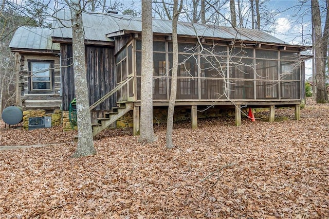 rear view of property featuring a sunroom