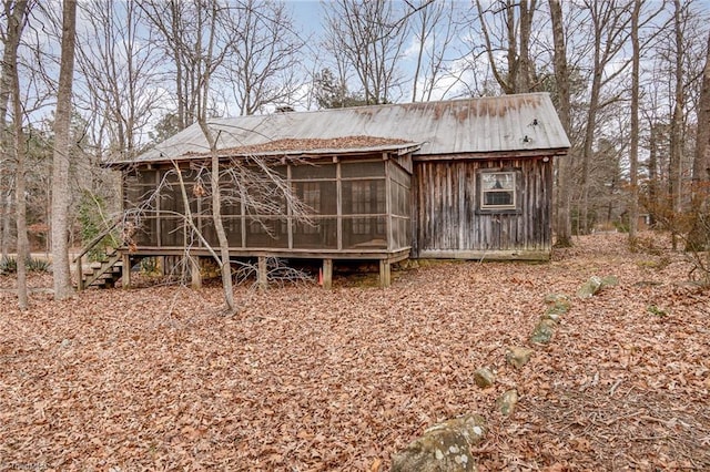 rear view of house featuring a sunroom