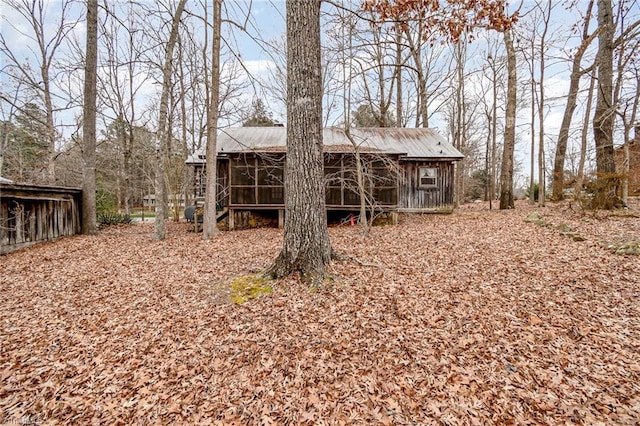 rear view of property featuring a sunroom