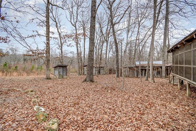 view of yard featuring a storage unit and a sunroom