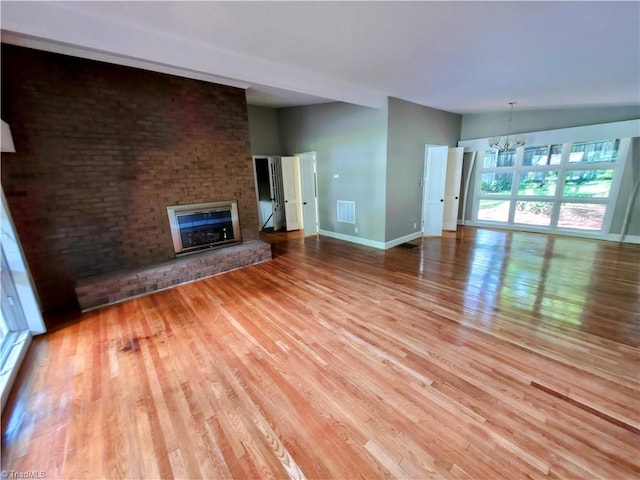 2841 Wesleyan Ln, Winston-Salem, NC 27106 - unfurnished living room featuring a chandelier, wood finished floors, a fireplace, and baseboards