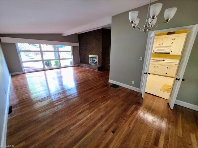 2841 Wesleyan Ln, Winston-Salem, NC 27106 - unfurnished living room with dark wood-style floors, a chandelier, and baseboards