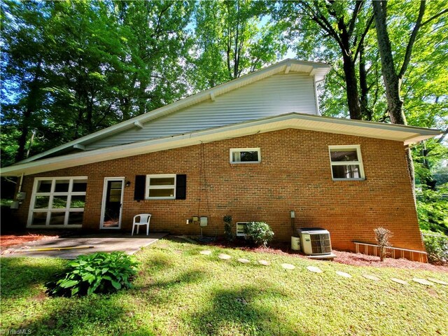 2841 Wesleyan Ln, Winston-Salem, NC 27106 - back of property featuring cooling unit, a patio area, brick siding, and a lawn