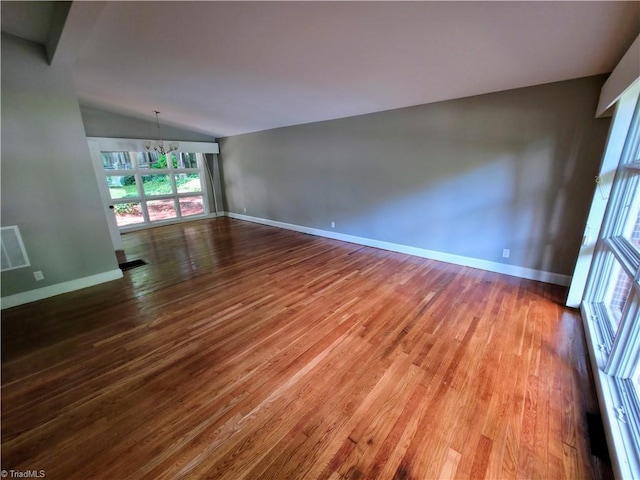 2841 Wesleyan Ln, Winston-Salem, NC 27106 - empty room featuring a chandelier, wood finished floors, lofted ceiling, and baseboards