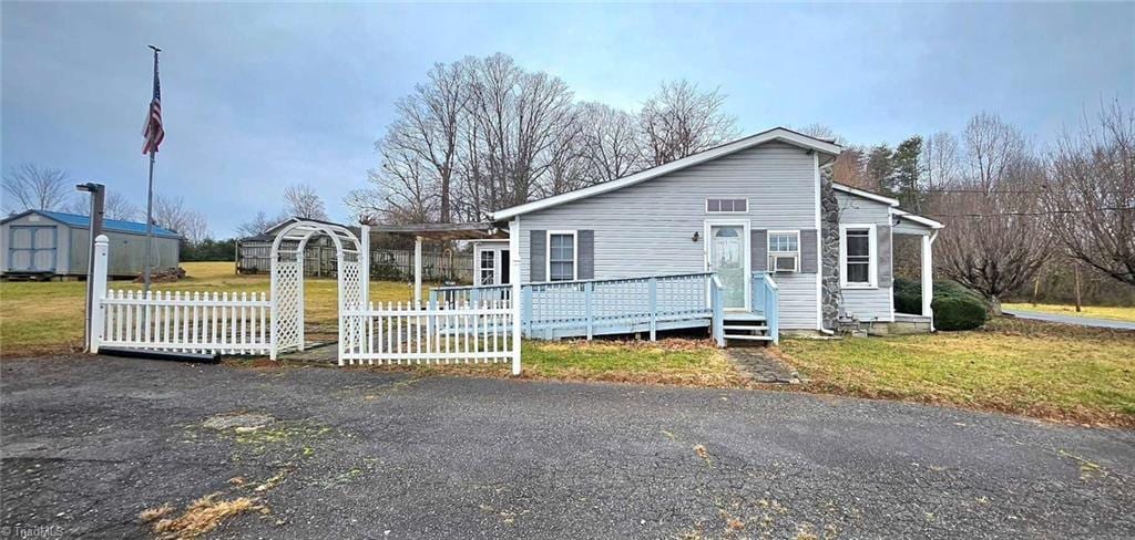 view of front of home with a front yard and a deck