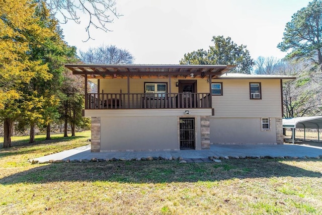 back of house featuring a lawn and a detached carport