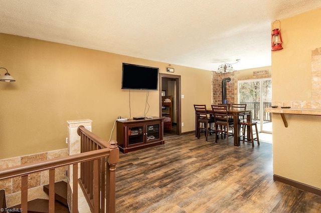 dining space featuring dark wood-style floors, a textured ceiling, and baseboards