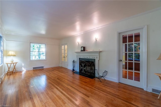 unfurnished living room with hardwood / wood-style flooring and ornamental molding