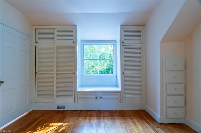 doorway to outside featuring vaulted ceiling and light hardwood / wood-style flooring