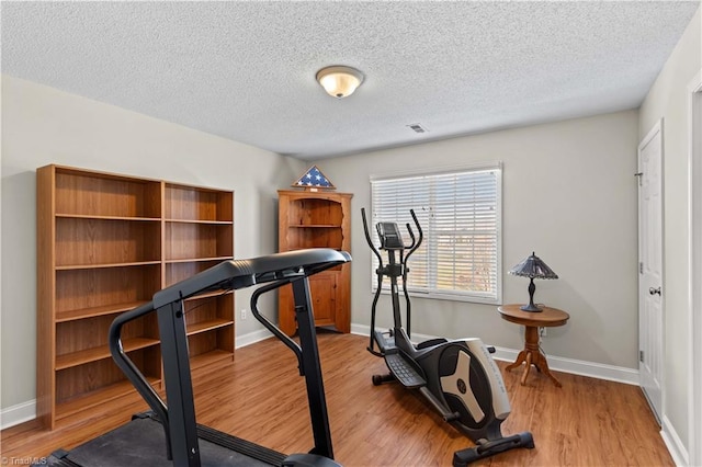 exercise area featuring a textured ceiling and hardwood / wood-style flooring