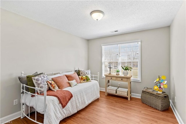 bedroom featuring wood-type flooring and a textured ceiling