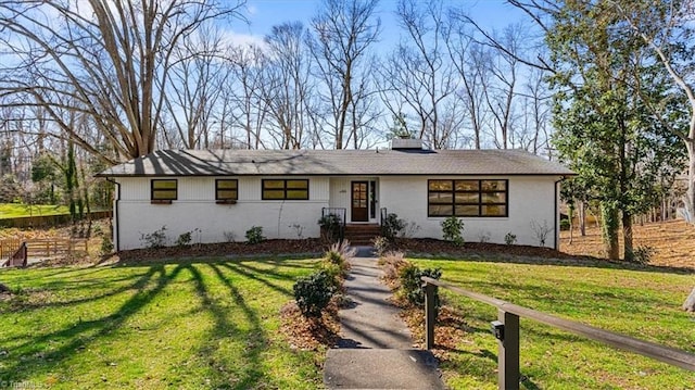 view of front of home with a front lawn and fence