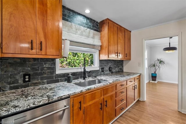 kitchen featuring tasteful backsplash, light stone countertops, ornamental molding, stainless steel dishwasher, and a sink