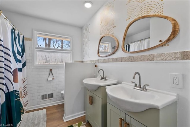 full bathroom featuring visible vents, toilet, a shower with shower curtain, wood finished floors, and vanity