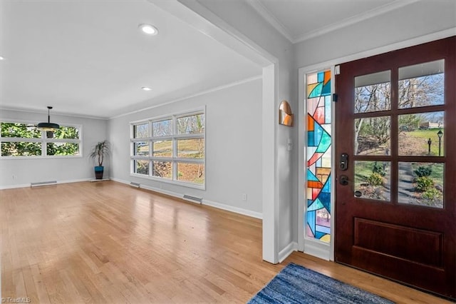 foyer entrance featuring wood finished floors, visible vents, baseboards, recessed lighting, and ornamental molding