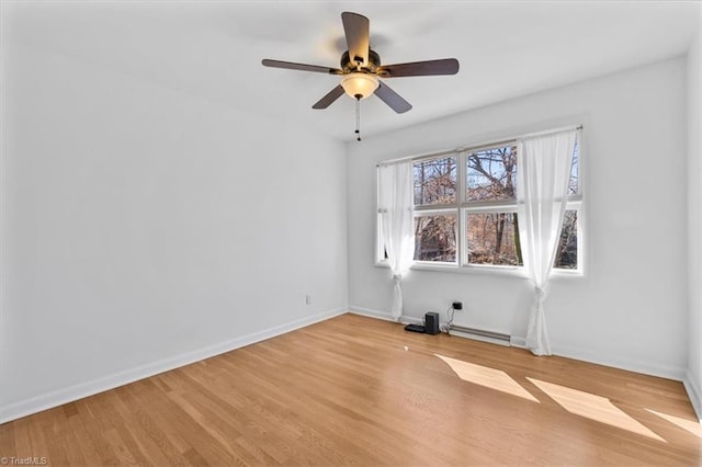 spare room featuring light wood-style floors, baseboards, baseboard heating, and ceiling fan