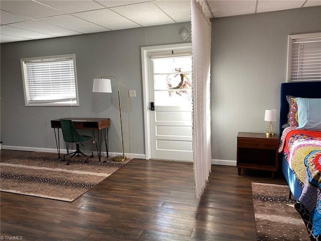 foyer with wood finished floors, baseboards, and a drop ceiling