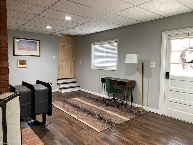 home office featuring wood finished floors, baseboards, and a paneled ceiling