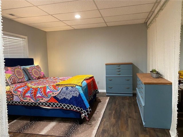 bedroom featuring dark wood-style floors, visible vents, and a paneled ceiling