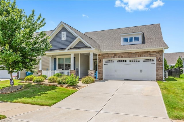 254 Kilbourne Dr, Advance, NC 27006 - craftsman-style home with stone siding, a porch, driveway, a front yard, and a garage