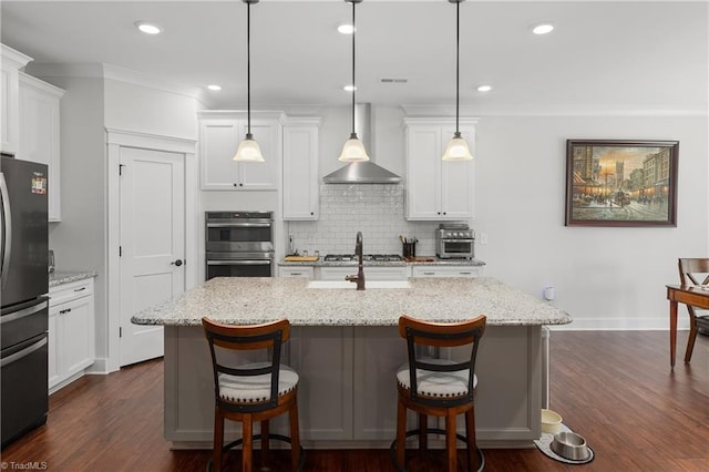 254 Kilbourne Dr, Advance, NC 27006 - kitchen featuring appliances with stainless steel finishes, wall chimney range hood, tasteful backsplash, white cabinets, and recessed lighting