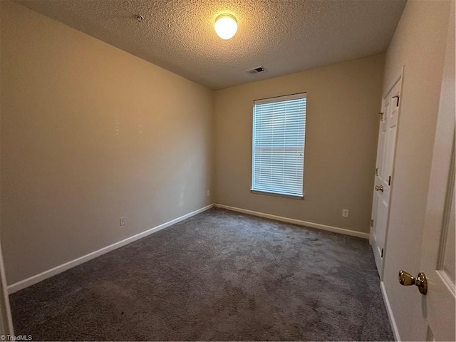 carpeted empty room with a textured ceiling