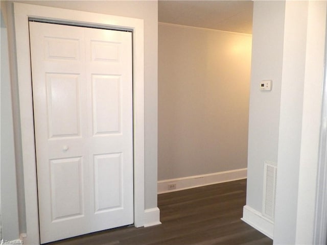 corridor with baseboards, visible vents, and dark wood finished floors