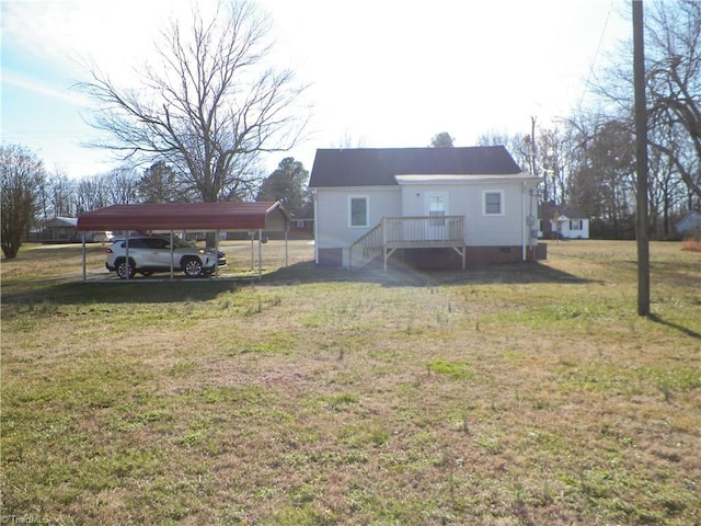 rear view of house with crawl space, a lawn, and a detached carport