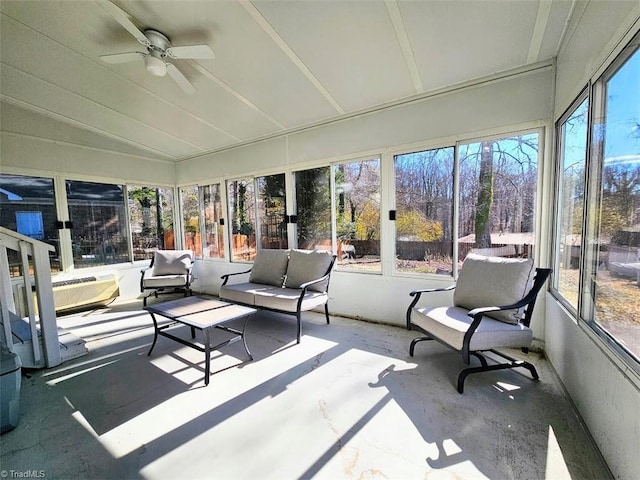 sunroom / solarium with lofted ceiling, plenty of natural light, and ceiling fan