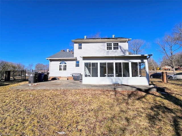 rear view of property with a patio, a sunroom, and a lawn