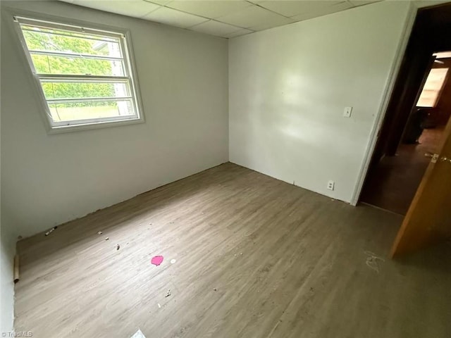 empty room with wood finished floors and a paneled ceiling