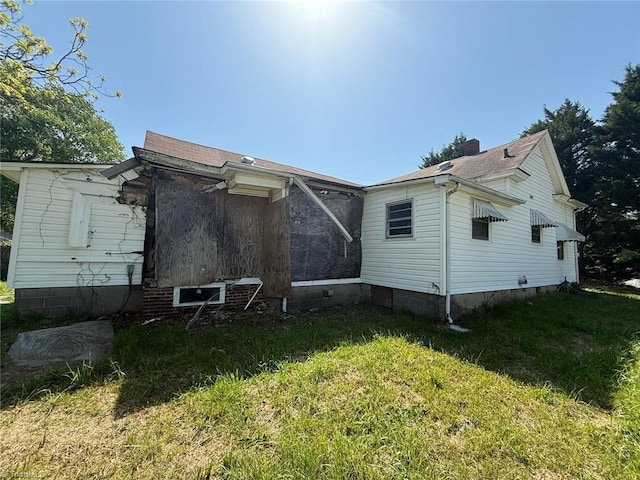 rear view of property featuring a yard