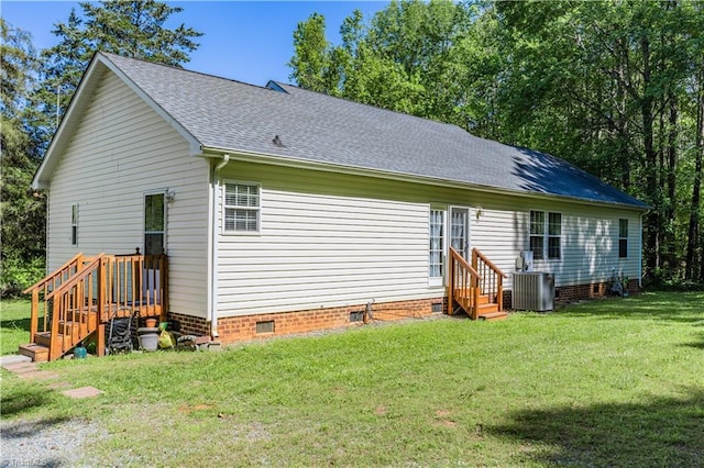 rear view of property with central air condition unit, crawl space, a yard, and roof with shingles