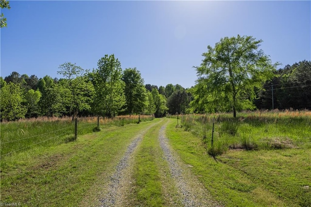 view of road with a rural view and a wooded view