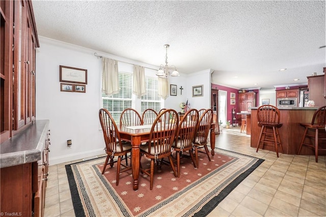 dining space with a textured ceiling, light tile patterned floors, baseboards, an inviting chandelier, and ornamental molding