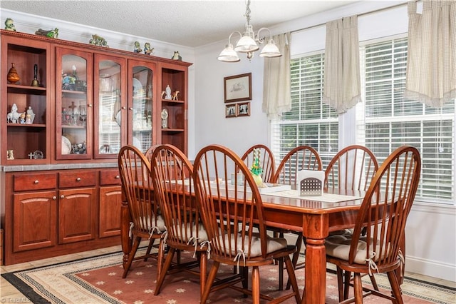 dining area featuring crown molding, an inviting chandelier, and plenty of natural light