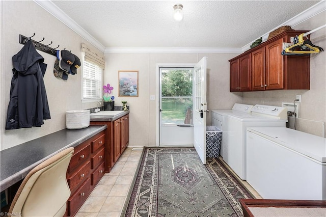 laundry room with cabinet space, a textured ceiling, a wealth of natural light, and washer and dryer
