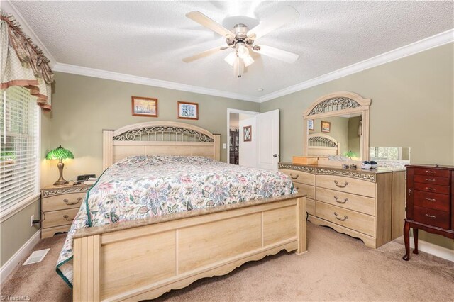 bedroom featuring light colored carpet, ornamental molding, and a textured ceiling