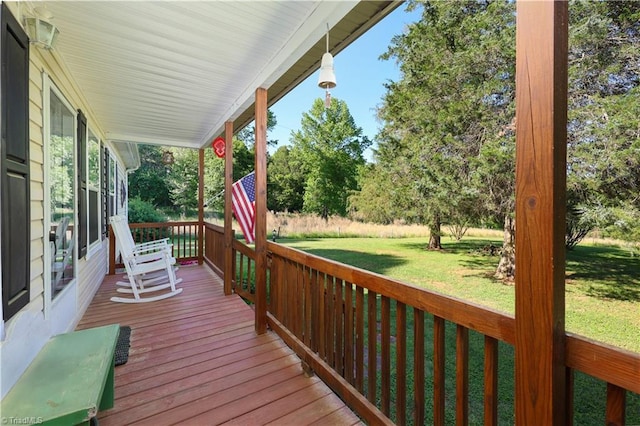 wooden terrace featuring a porch and a yard
