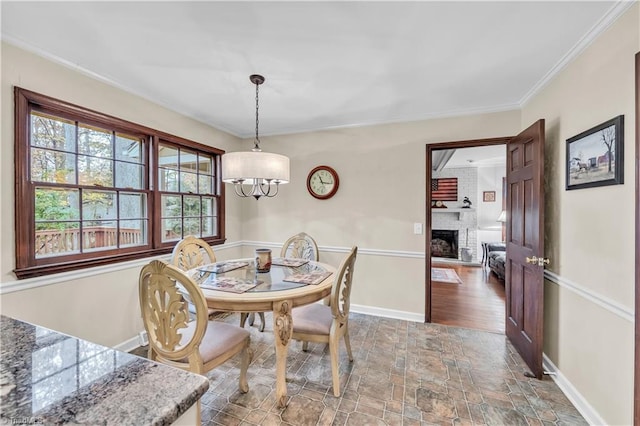 dining space with hardwood / wood-style flooring, a brick fireplace, and crown molding