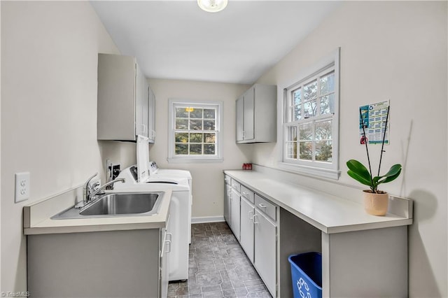 laundry room featuring washer and dryer, plenty of natural light, cabinets, and sink